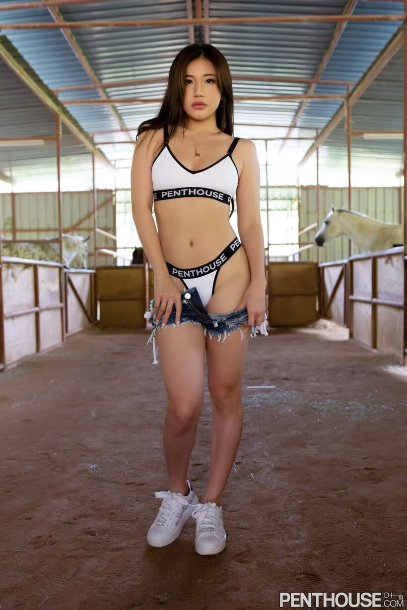 Image 8/21: Naked Asian model poses in sneakers inside the stable