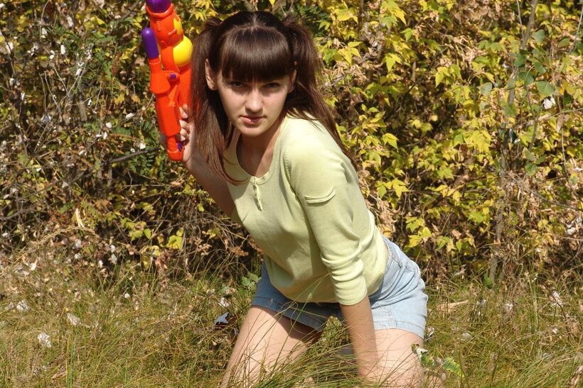 Image 2/21: Outdoors, a playful teen undresses fully and shows her bare pussy close-up