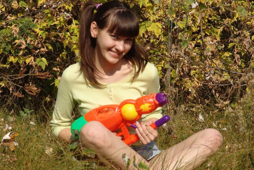 Outdoors, a playful teen undresses fully and shows her bare pussy close-up (shot 5)