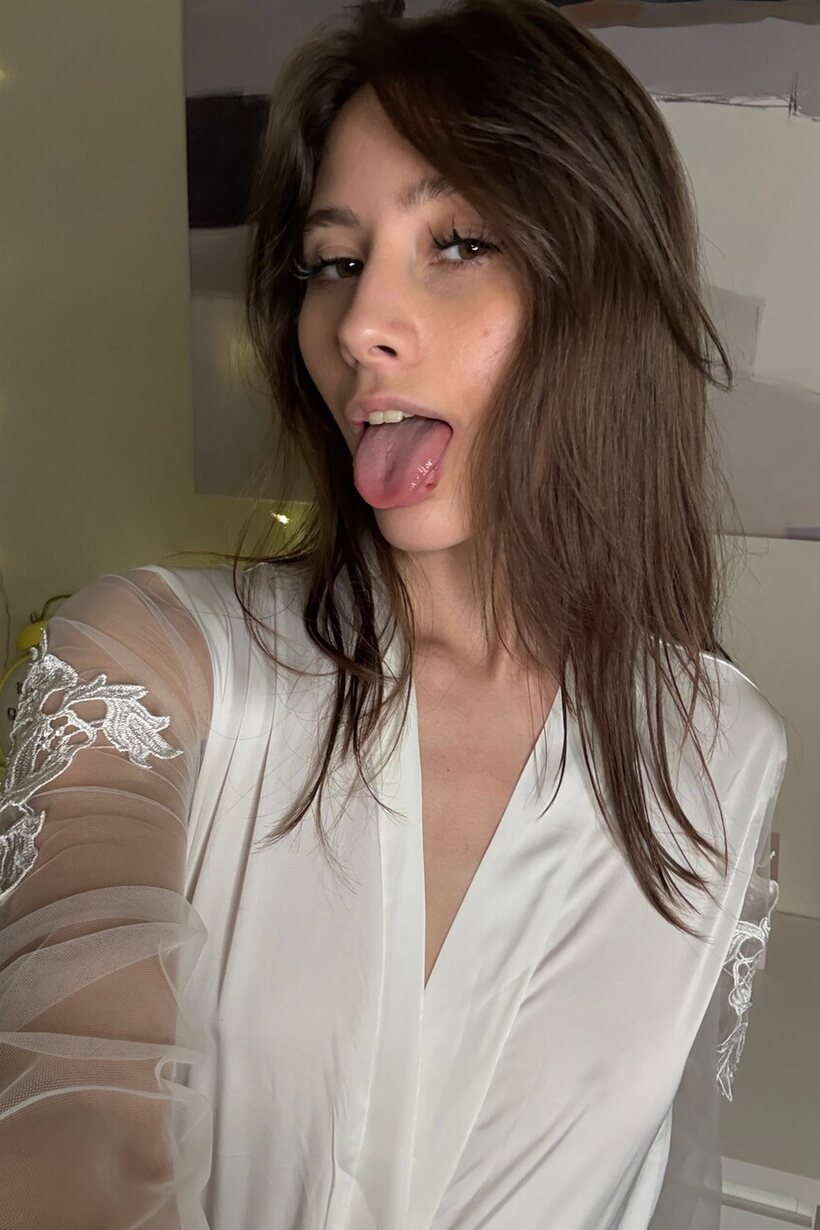 Image 14/20: Tongue out, solo babe slips into lingerie for a selfie