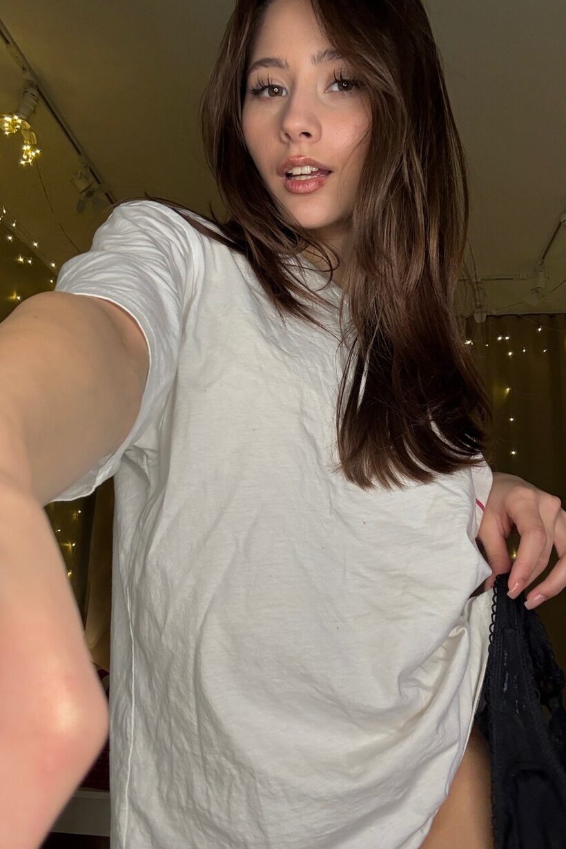 Image 15/20: Tongue out, solo babe slips into lingerie for a selfie