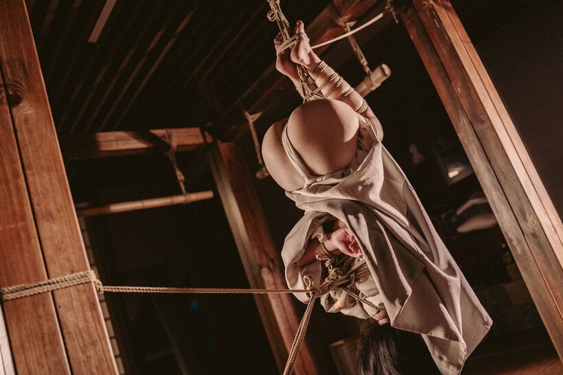 Photo 2 — Bound upside down, an Asian babe teases her big booty