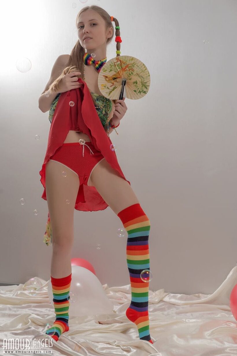 Photo 5 — Pigtail teen in colorful socks strips off her clothes