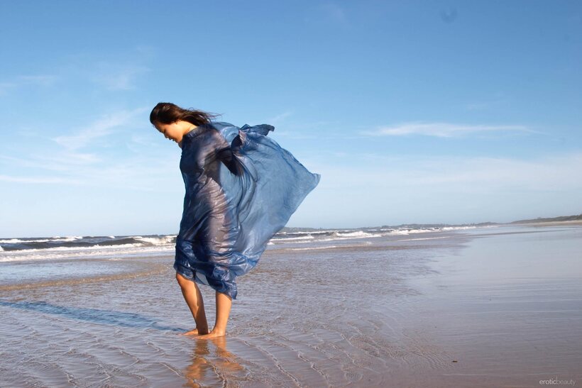 Slim Asian babe stands naked in the surf during low tide (shot 19)