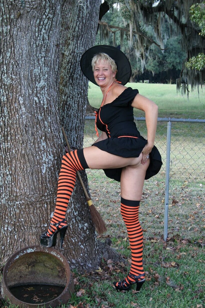 Photo 3 — Outdoors in a Halloween costume, Tracy Lick teases her ass with a broom