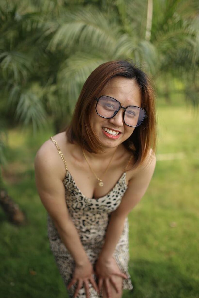 Image 3/21: Eyeglasses and leopard dress frame this sweet Asian babe outdoors