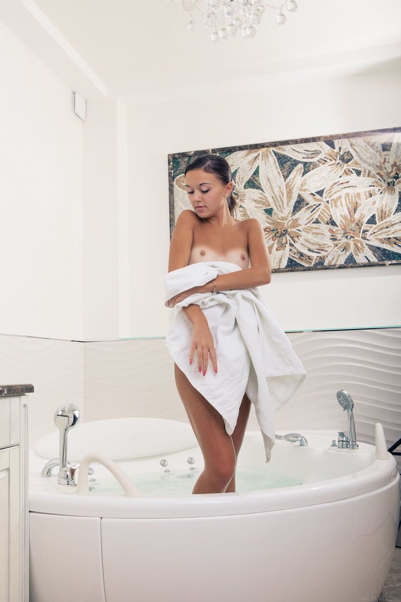 Image 21/21: Veselin peels off her bathrobe before slipping into the bath