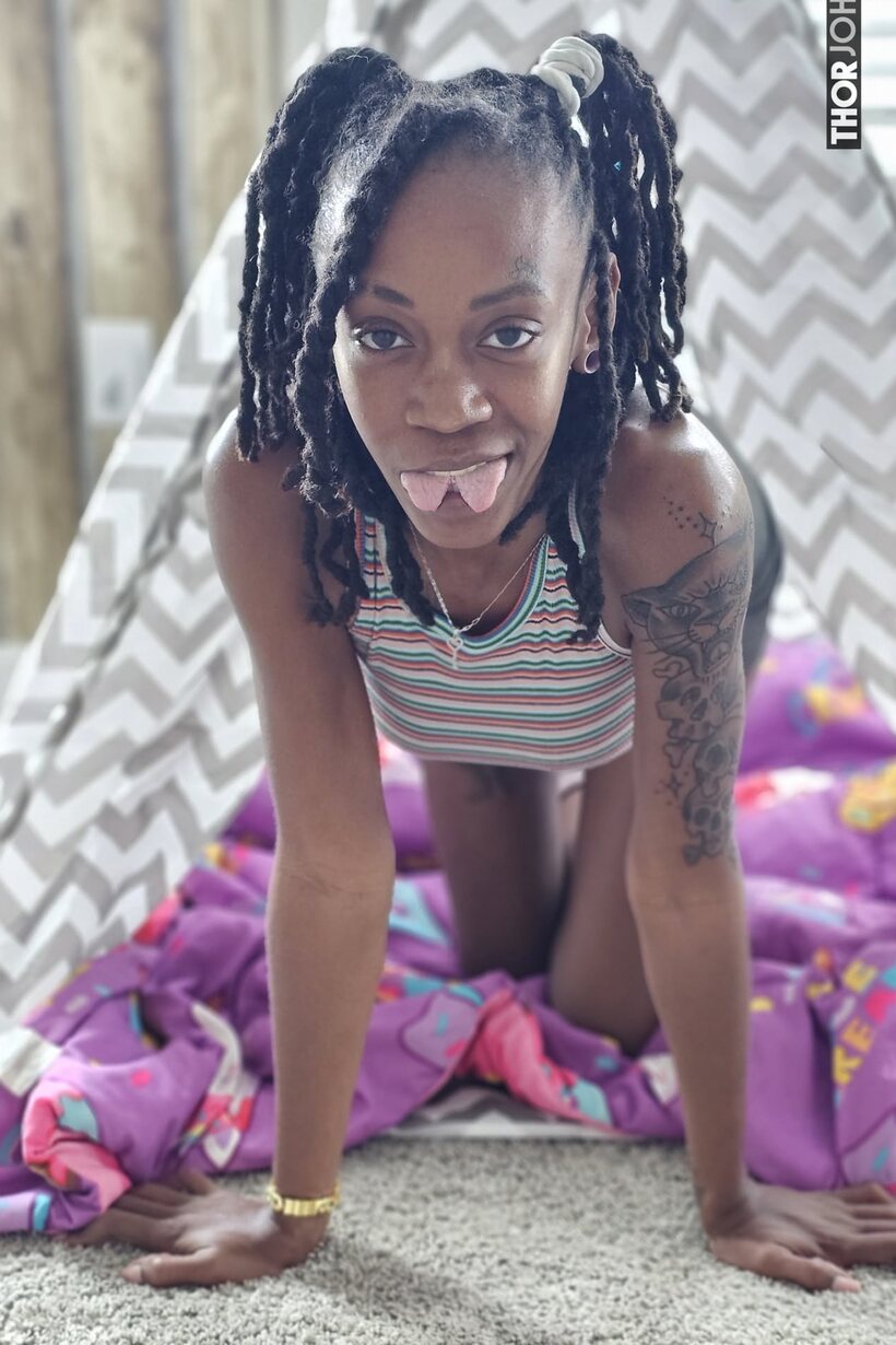 Photo 2 — Tongue out, cute ebony girl slips her big booty from a thong