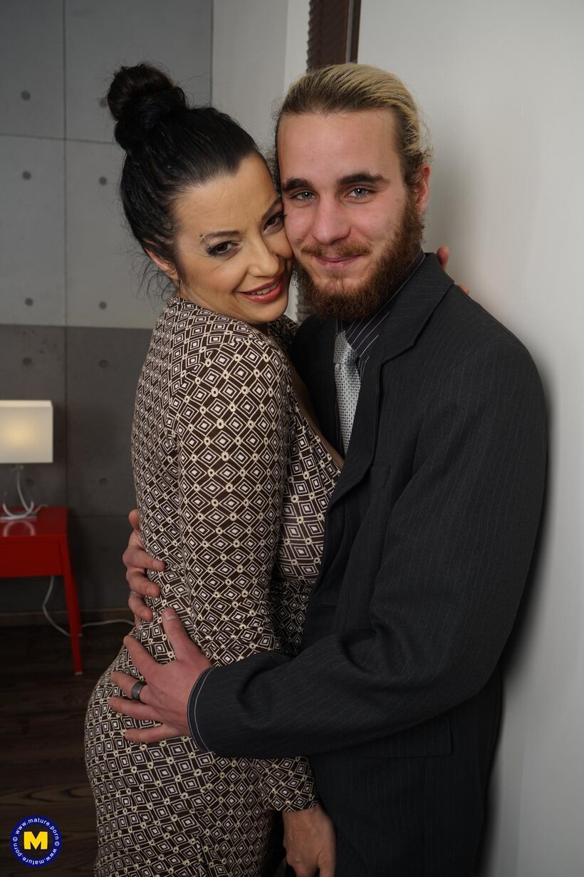Image 4/16: An older brunette seduces a suited younger man and fucks him