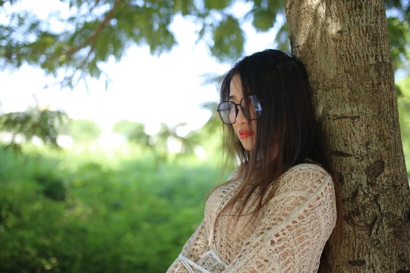 Image 4/21: Posing in a cute outfit outdoors, Elena shows off her glasses and Asian charm