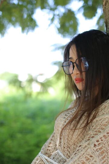 Posing in a cute outfit outdoors, Elena shows off her glasses and Asian charm