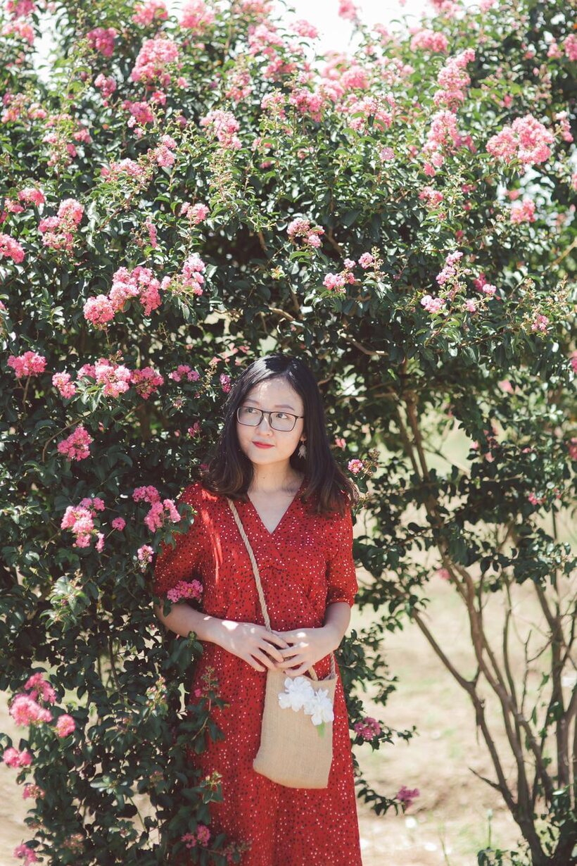 Photo 2 — Glasses on, an Asian babe poses outdoors in a red dress
