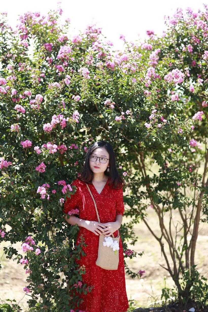 Image 4/21: Glasses on, an Asian babe poses outdoors in a red dress