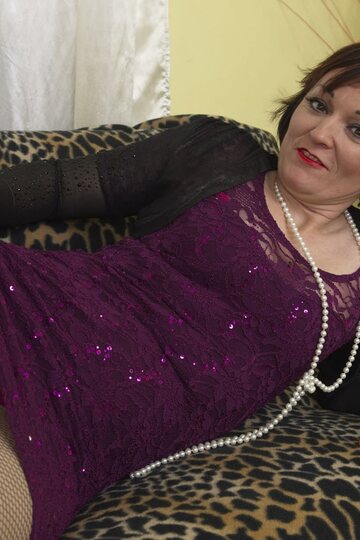 Red-lipped mature lady strips down wearing a pearl necklace and skirt