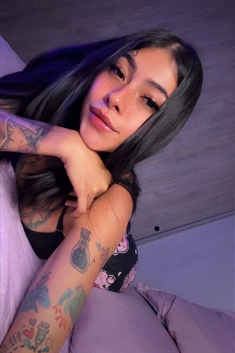 Image 12/20: Tattooed brunette models outfits solo in a non-nude pose