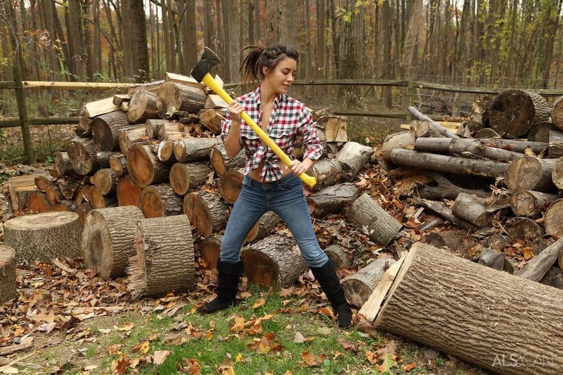 Daisy Haze strips down to boots while chopping wood outdoors, photo 1 of 16