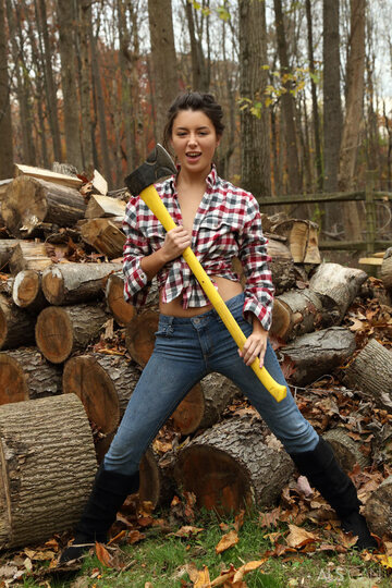 Daisy Haze strips down to boots while chopping wood outdoors