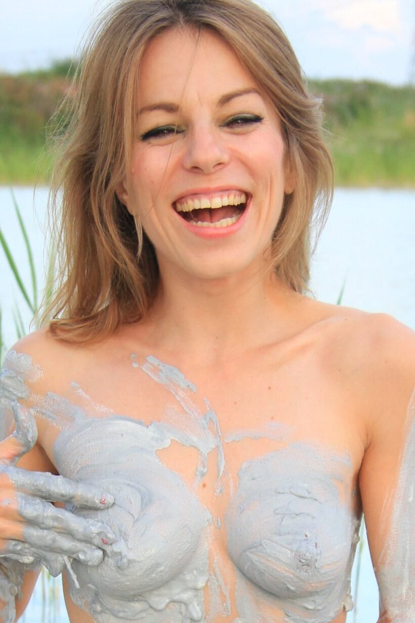 Photo 21 — Naked muddy babe wades through water with her ass covered
