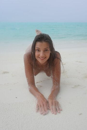 Melena Tara goes nude on the beach, letting sand coat her body