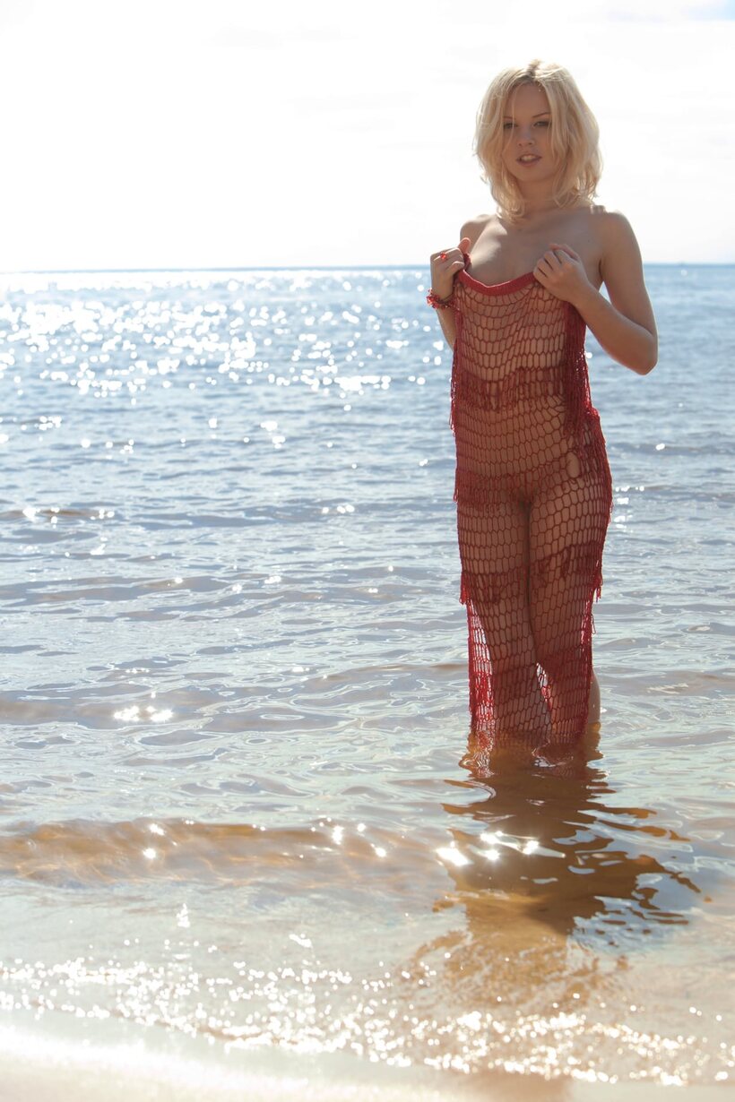 Nude blonde babe with perky tits poses on a sandy beach, photo 17 of 21