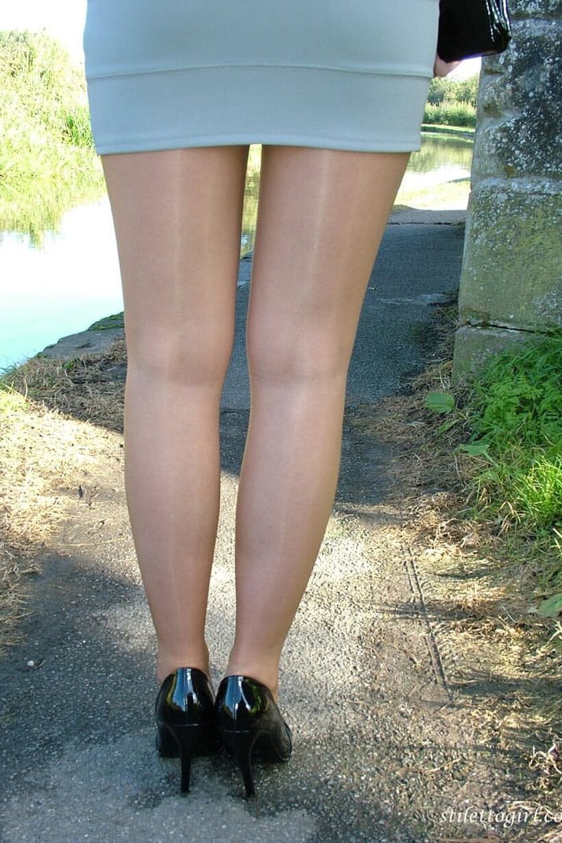 Blonde babe poses on the footpath in a miniskirt and black pumps (shot 15)