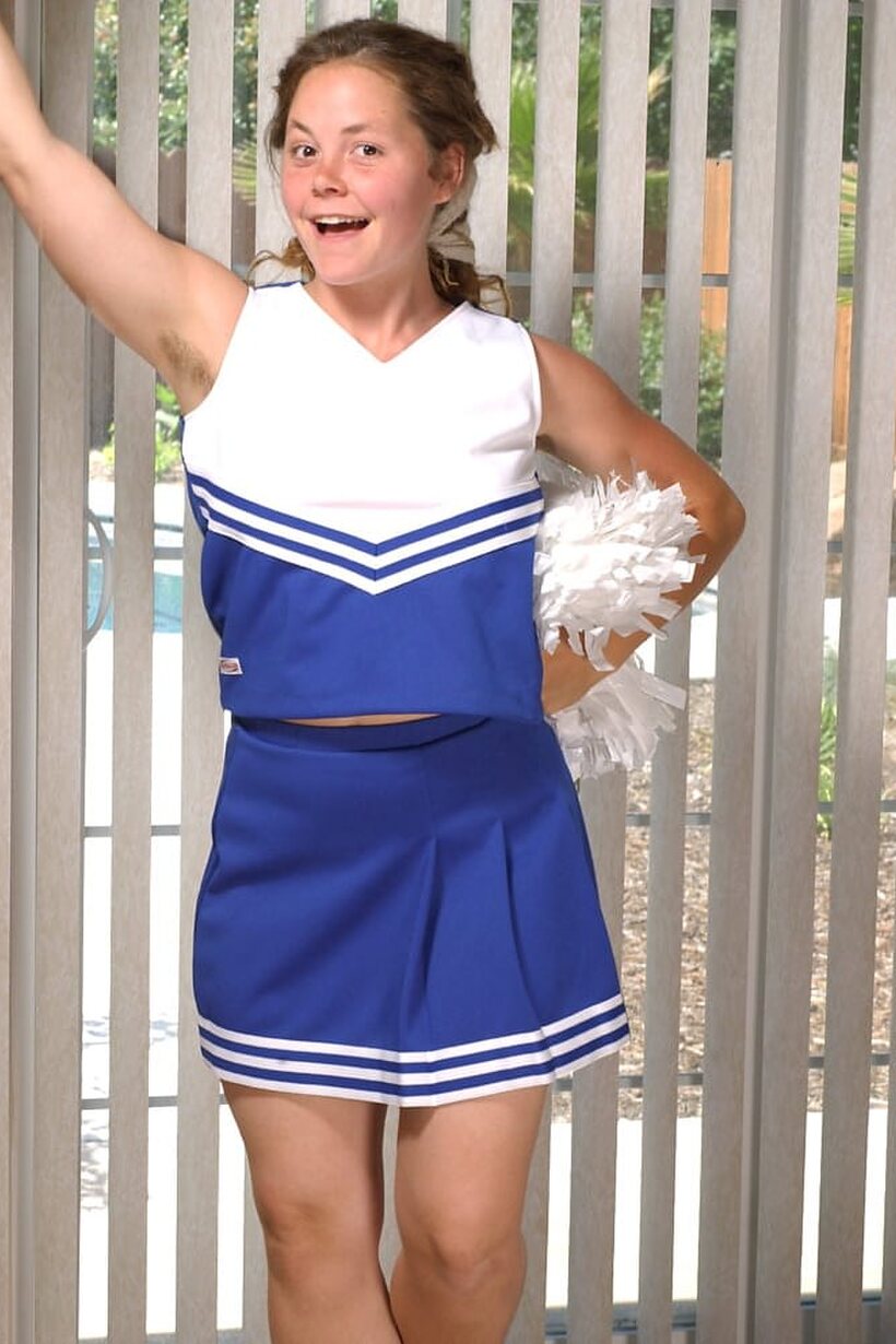 Photo 2 — Redhead cheerleader slips her underwear down to finger her bush outdoors