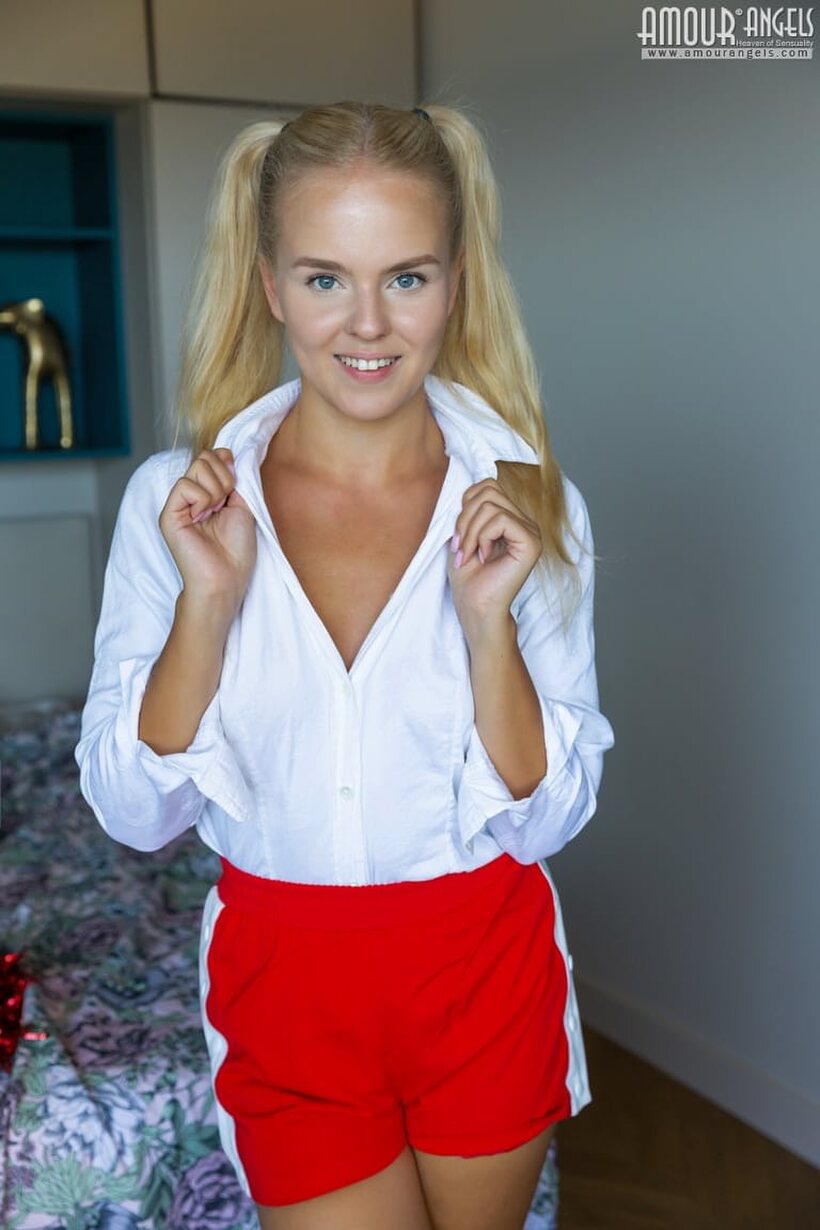 Image 3/20: Blonde teen Decima strips with pom-poms in her hands