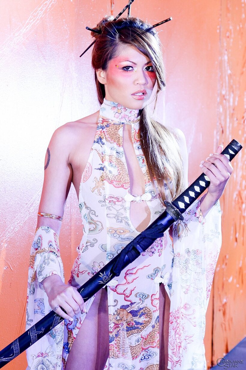 Image 3/15: Charmane Star strips to heels while posing with a sword