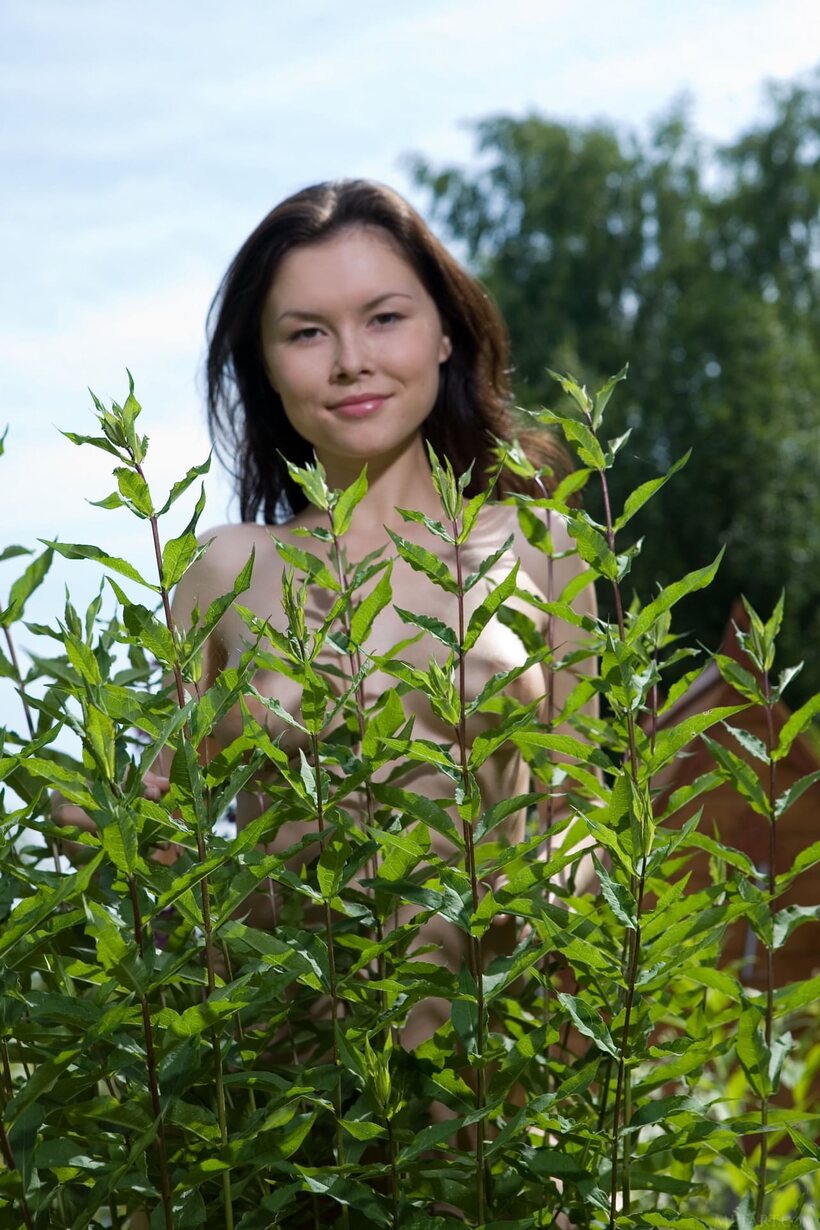 Image 12/21: Naked bushy teen in the backyard displays her trimmed armpits and ass