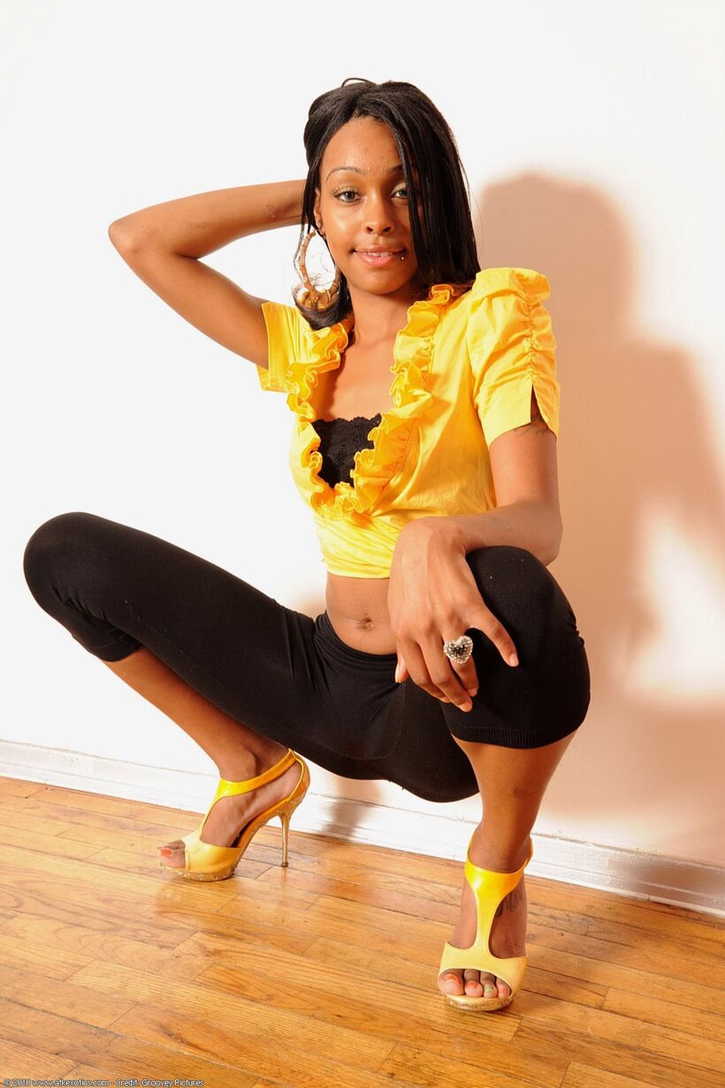 Photo 2 — Black girl slips out of spandex and bra, then poses nude in heels