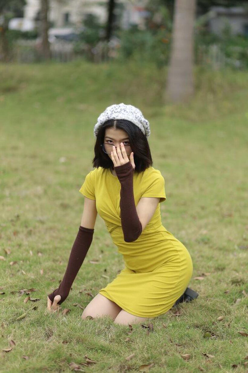 Irena poses in a yellow dress and glasses, looking shy (shot 2)