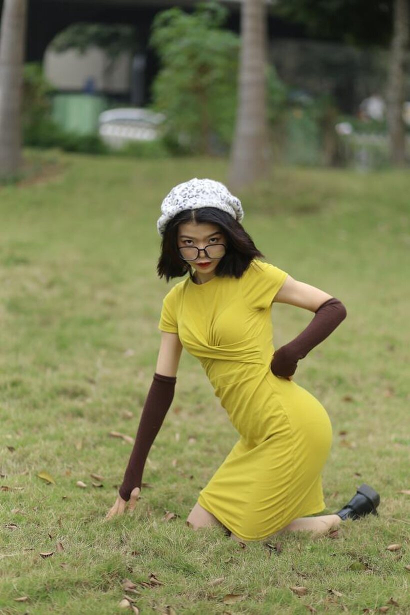 Image 7/21: Irena poses in a yellow dress and glasses, looking shy