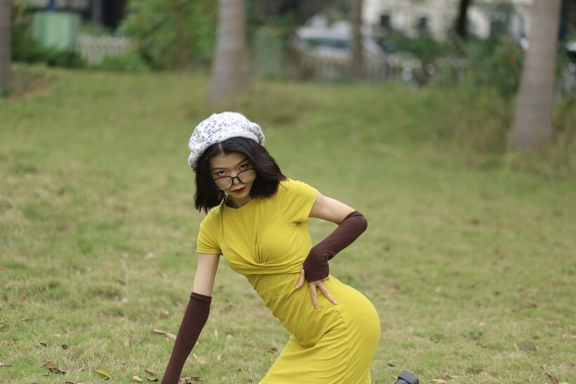 Irena poses in a yellow dress and glasses, looking shy (shot 8)