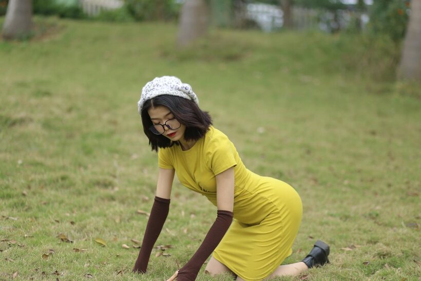 Photo 9 — Irena poses in a yellow dress and glasses, looking shy