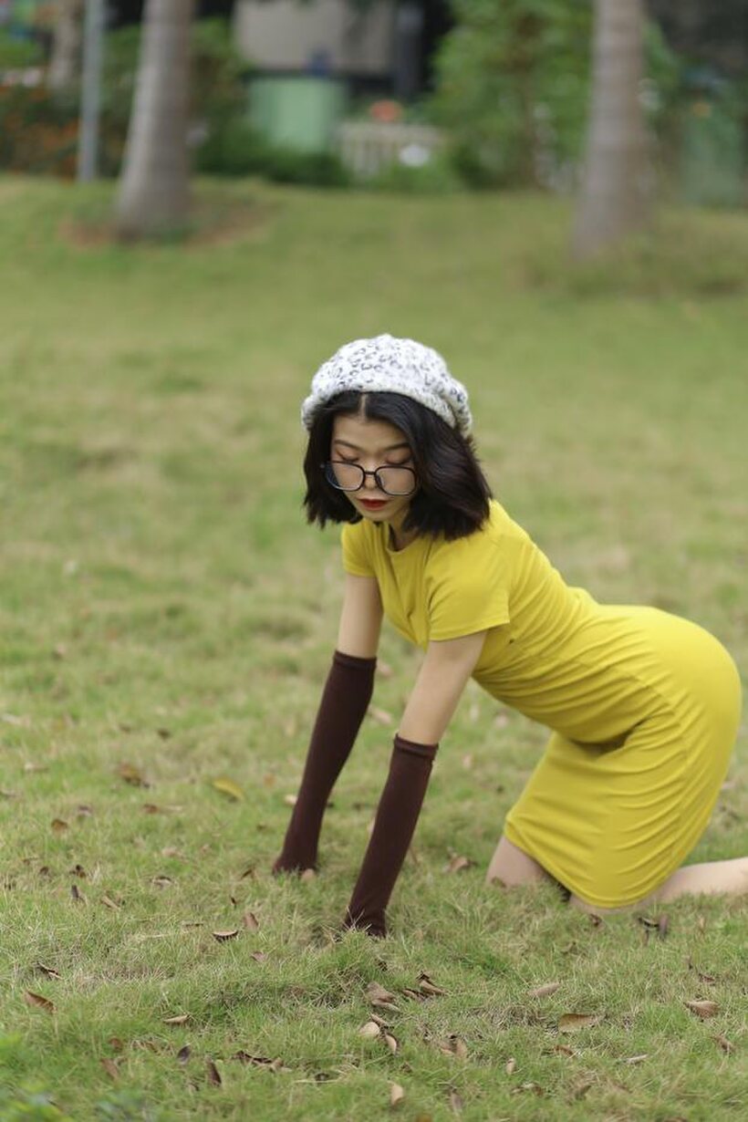 Irena poses in a yellow dress and glasses, looking shy (shot 10)