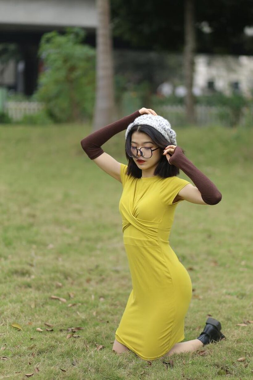 Irena poses in a yellow dress and glasses, looking shy (shot 12)