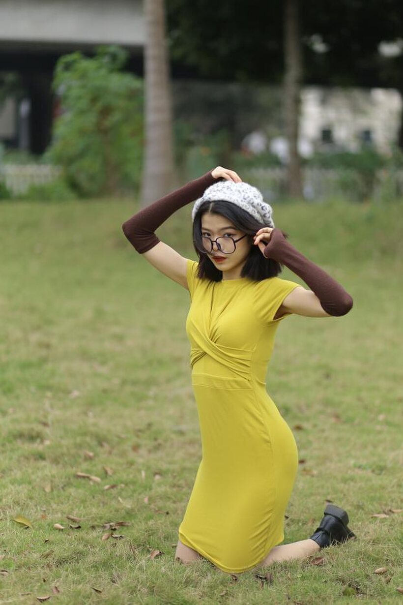 Irena poses in a yellow dress and glasses, looking shy (shot 13)