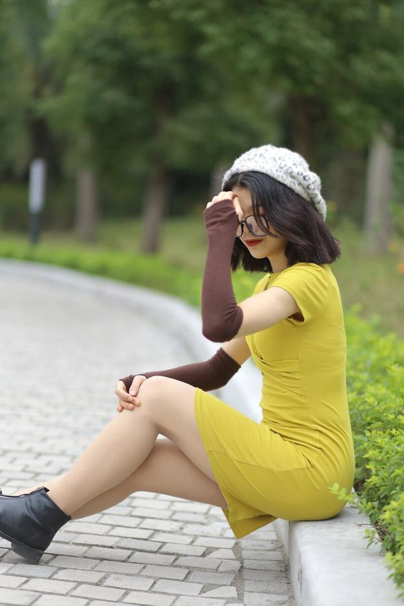 Irena poses in a yellow dress and glasses, looking shy (shot 18)
