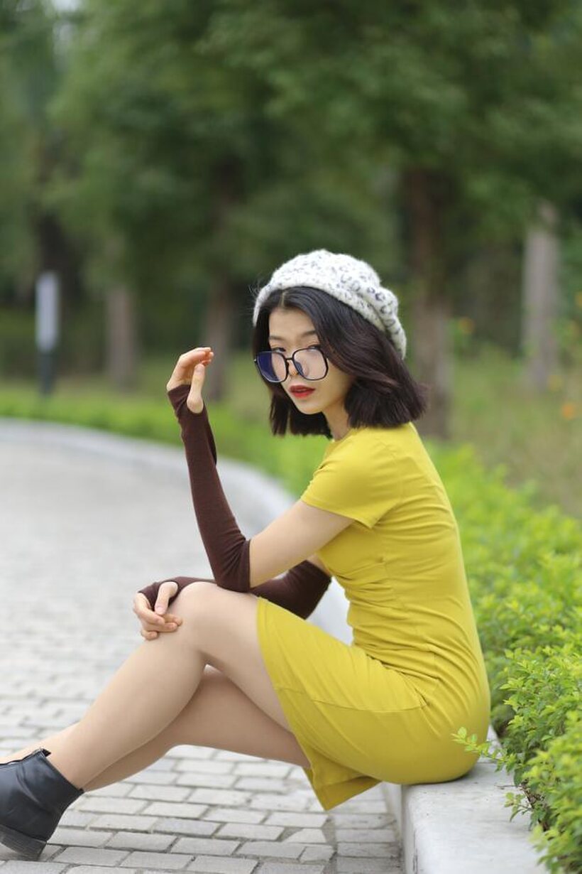 Image 20/21: Irena poses in a yellow dress and glasses, looking shy