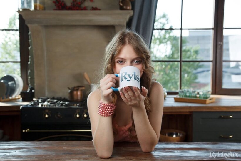 Naked on the kitchen table, Siya poses beside a cup of coffee (shot 4)