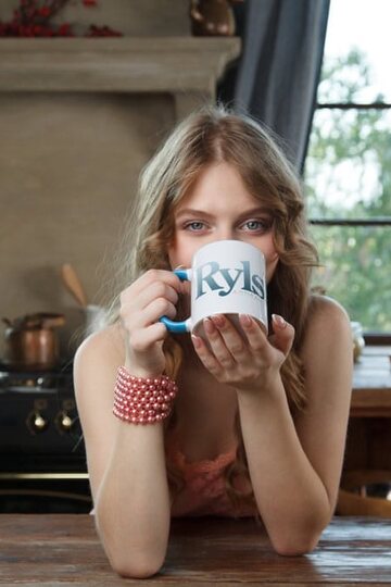 Naked on the kitchen table, Siya poses beside a cup of coffee