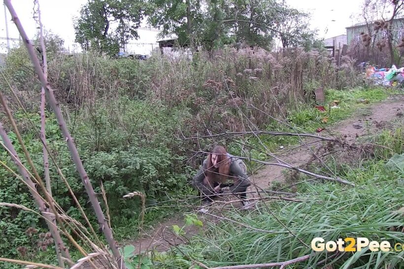 Denisa spreads her legs and pisses along a dirt path, photo 5 of 15