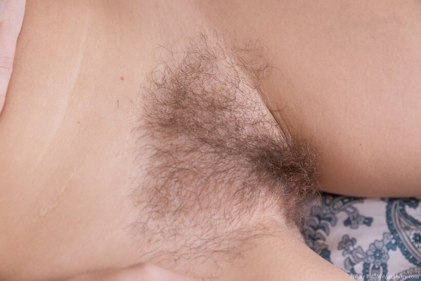 Nikky B strips off and fingers her hairy pussy in solo play, photo 20 of 21