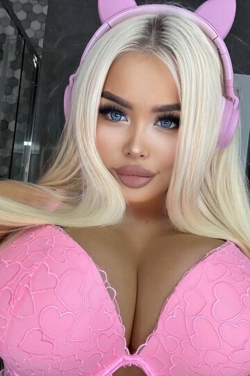 Blonde glamour babe displays her shaved pussy in a top