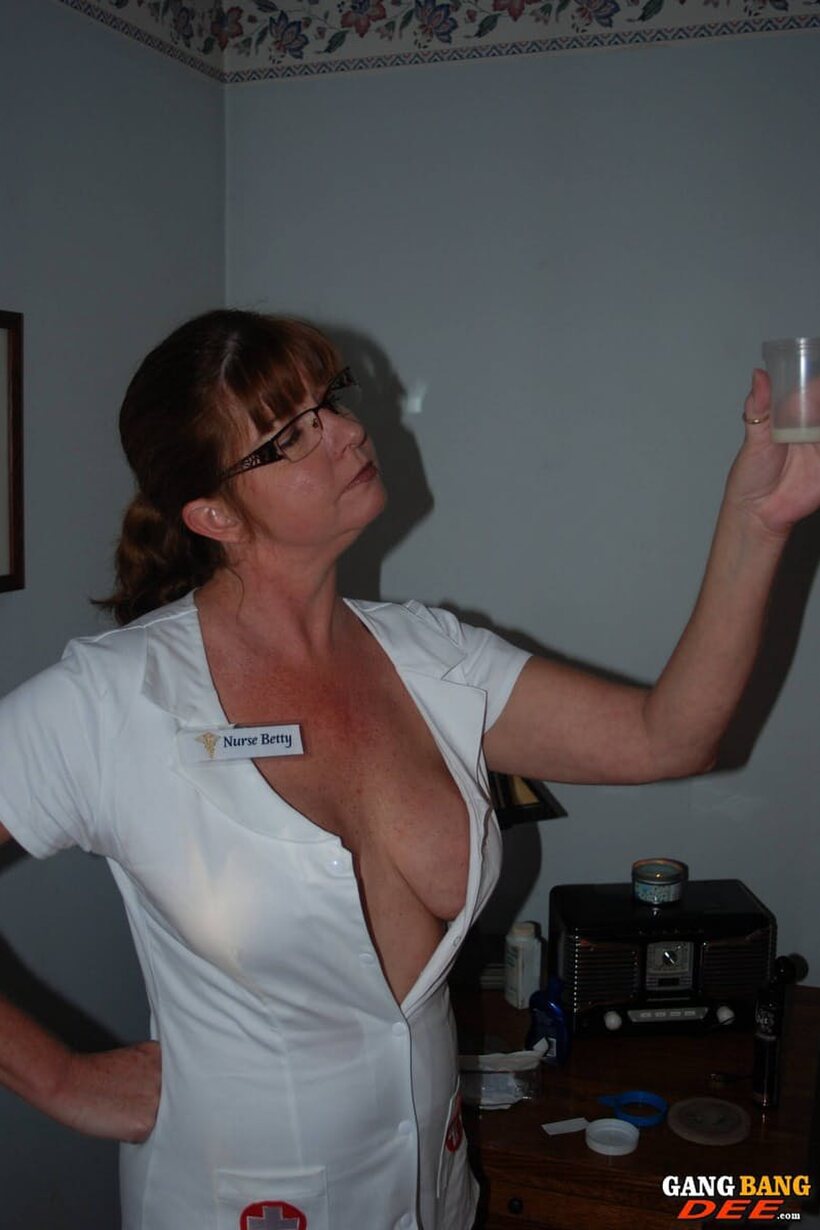 Image 19/21: In glasses, Dee Delmar in a nurse uniform gives a hot handjob
