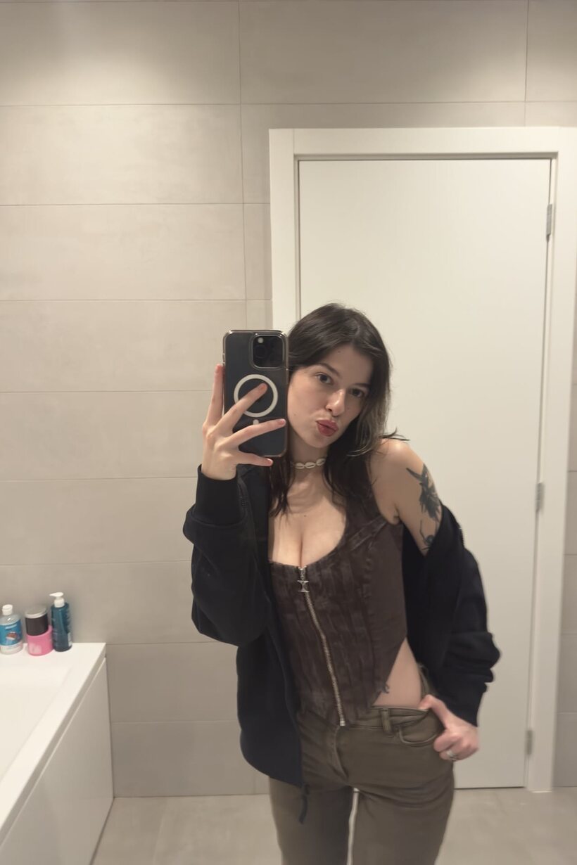 Image 11/12: Brunette model swaps outfits while shooting selfies in shorts