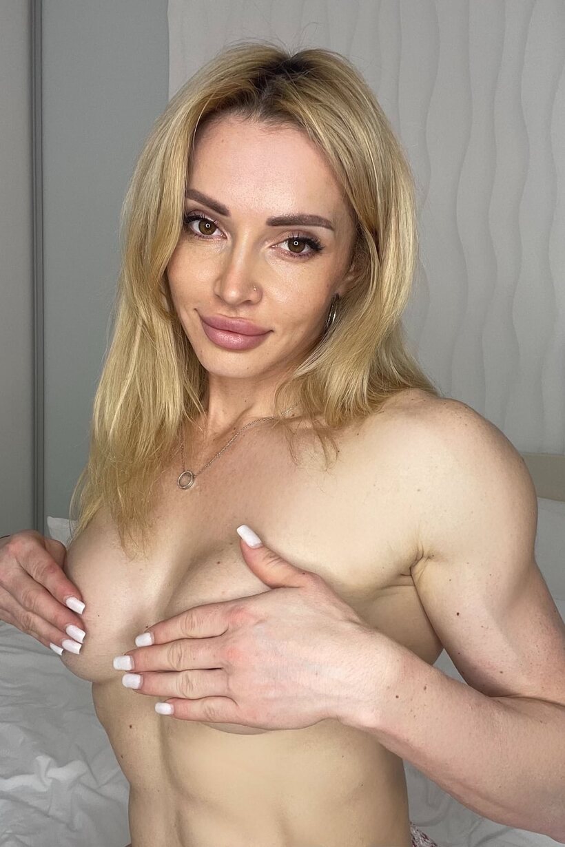 Slipping out of one bra, a blonde bodybuilder puts on another with thong (shot 4)