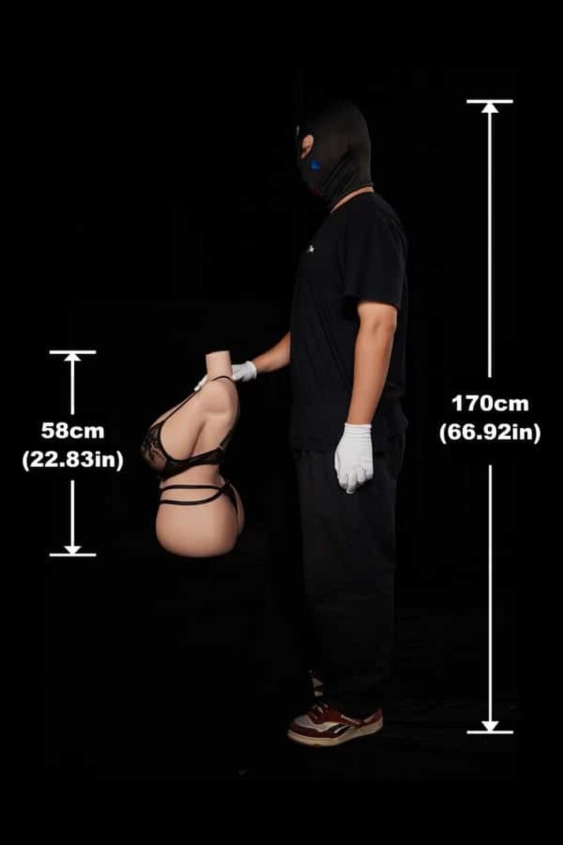 In a dark room, a fully clothed man cradles a naked sex doll (shot 2)