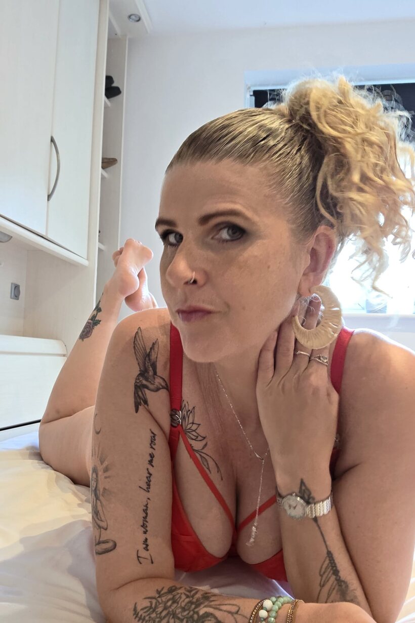 Photo 1 — Red lingerie and a pierced lip frame this tattooed BBW solo scene