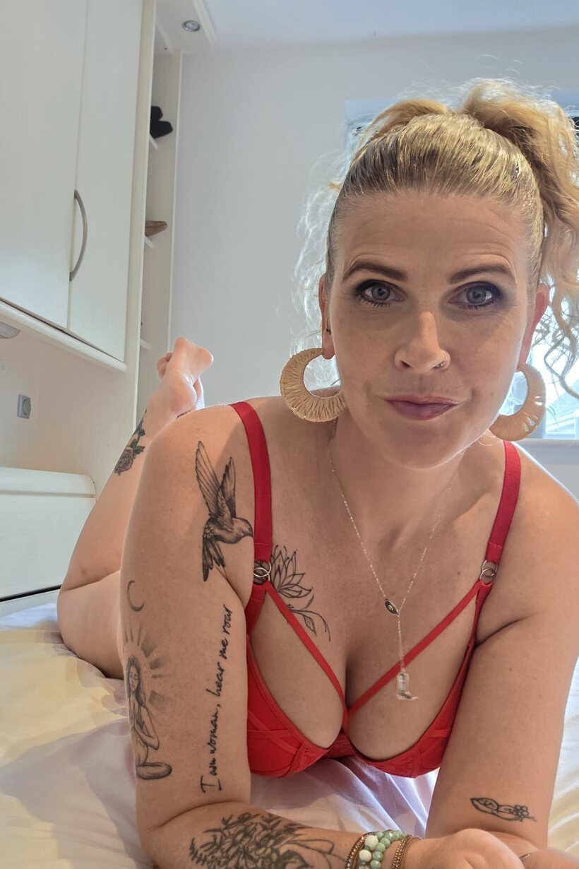 BBW nude photo 3 — Red lingerie and a pierced lip frame this tattooed BBW solo scene